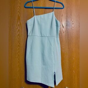 Body shaping short blue dress with asymmetrical cut and slit.